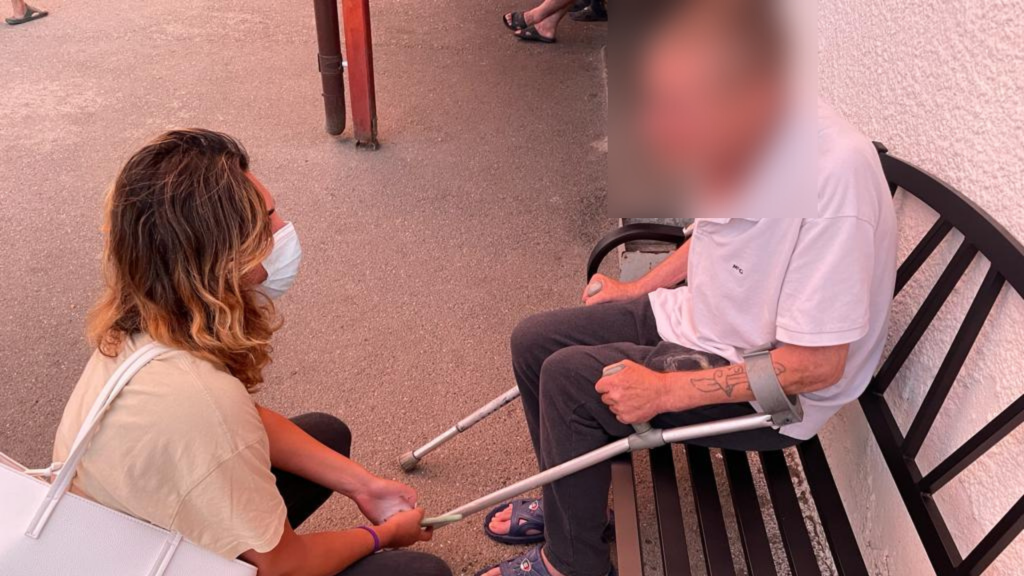 O persoană cu dizabilități și în cârje stă pe bancă. Discută cu un specialist CRJ.